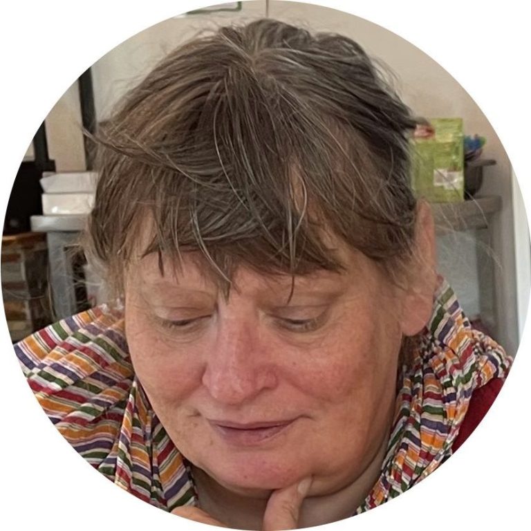 Vrouw met een begripvolle uitstraling, zittend met hand onder de kin.
