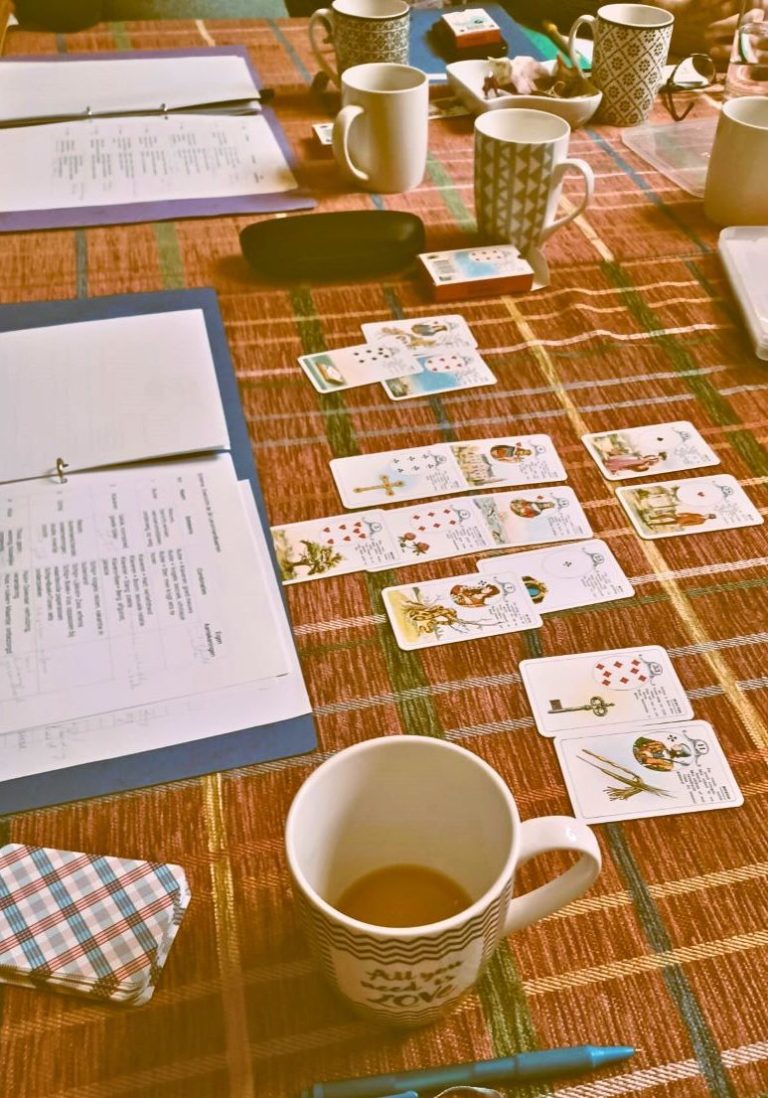 Studietafel met kaarten en een koffiekop op een tafel met een ruitpatroon.